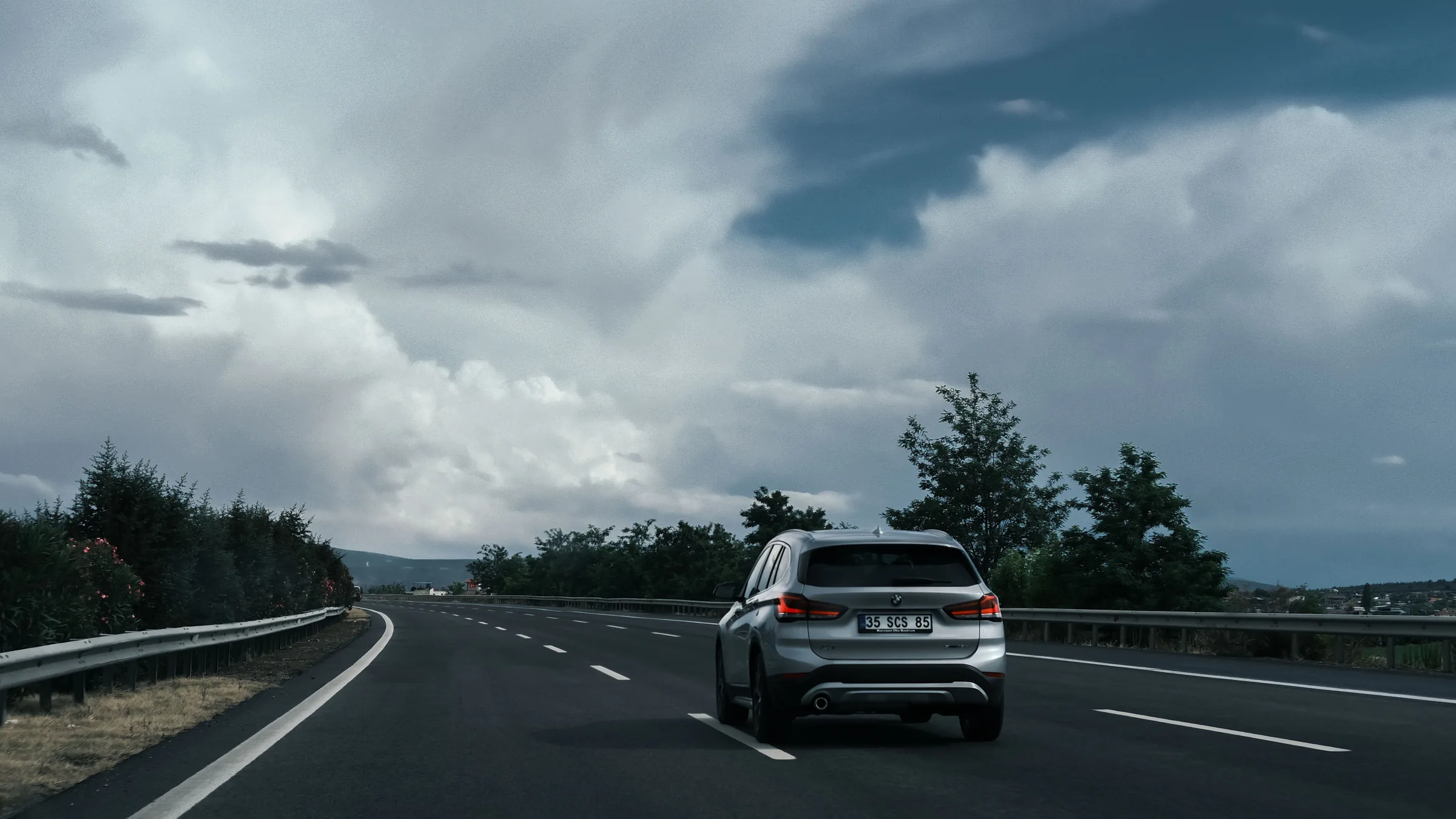 Coche circulando por una carretera de Navarra bajo un cielo nublado